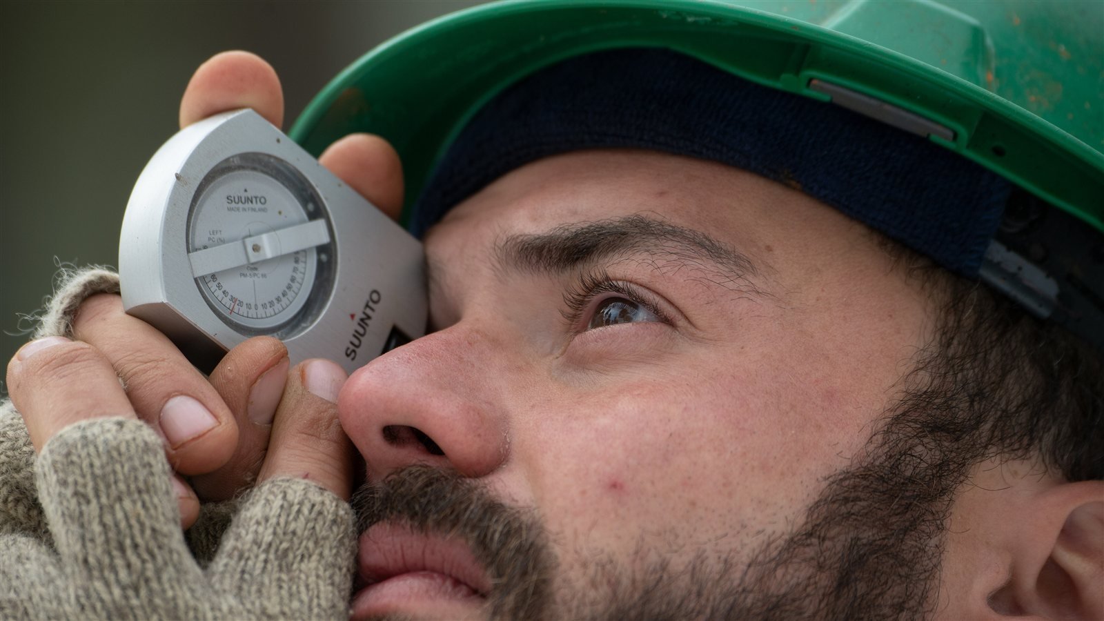 Forestal usando un clinómetro Suunto para medir el ángulo de inclinación hacia la copa de un árbol